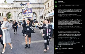 A group of individuals partake in a demonstration for environmental awareness, specifically addressing the fashion industry's impact on the planet, as they march with signs, banners, and a creative display of clothing suspended in the air; against the backdrop of an urban setting with classical architecture.